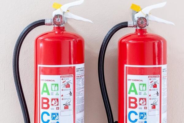 Two fire extinguishers with ABC sticker.