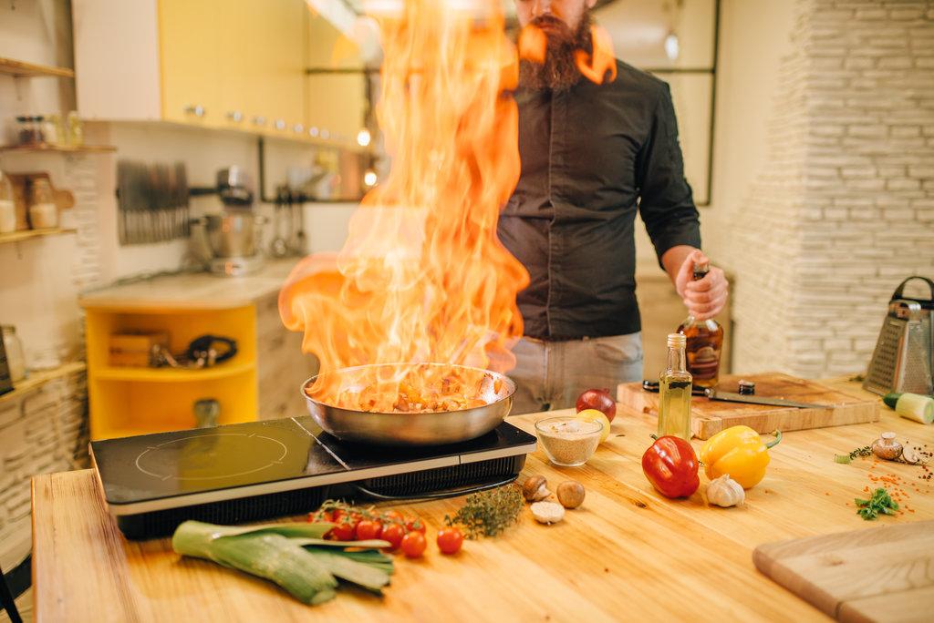 Male cooking with huge fire.