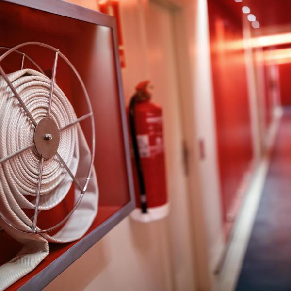 Fire extinguisher and hose reel in hotel corridor.